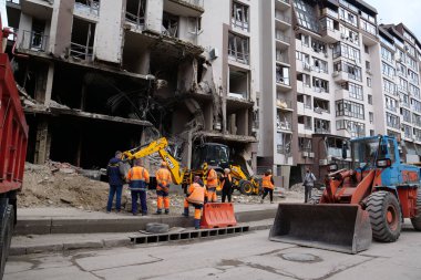 KYIV, UKRAINE, APRIL 29, 2022: Workers clear rubble after bombing. Dwelling house damaged by russian missile on April 28, 2022. War in Ukraine. Terror and genocide of Ukrainian people