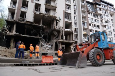 KYIV, UKRAINE, APRIL 29, 2022: Workers clear rubble after bombing. Dwelling house damaged by russian missile on April 28, 2022. War in Ukraine. Terror and genocide of Ukrainian people