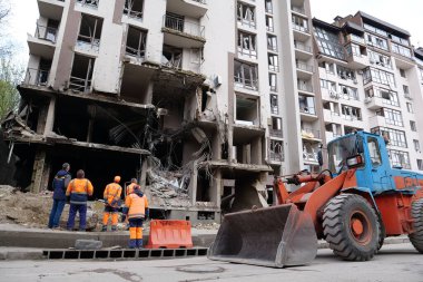 KYIV, UKRAINE, APRIL 29, 2022: Workers clear rubble after bombing. Dwelling house damaged by russian missile on April 28, 2022. War in Ukraine. Terror and genocide of Ukrainian people