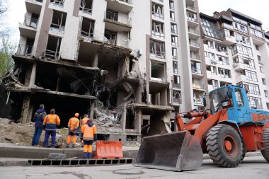 KYIV, UKRAINE, APRIL 29, 2022: Workers clear rubble after bombing. Dwelling house damaged by russian missile on April 28, 2022. War in Ukraine. Terror and genocide of Ukrainian people