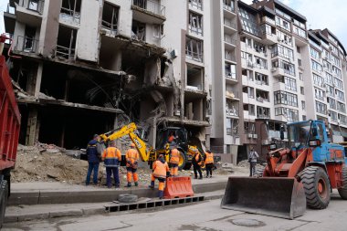KYIV, UKRAINE, APRIL 29, 2022: Workers clear rubble after bombing. Dwelling house damaged by russian missile on April 28, 2022. War in Ukraine. Terror and genocide of Ukrainian people