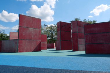 Spor sahasında parkur ve serbest dolaşım için açık hava spor sahasında yeni egzersiz ekipmanları bulunuyor.