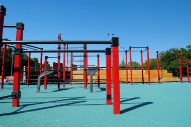 Şehirdeki açık hava spor sahasında yatay çubukları ve diğer yeni egzersiz ekipmanlarıyla spor sahası. Açık havada fiziksel egzersiz için spor sahası