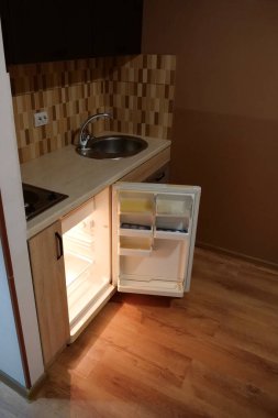 Built-in empty mini fridge with open door in the kitchen