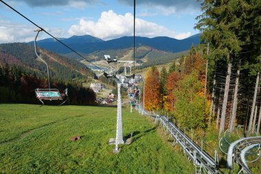 BUKOVEL, UKRAINE, OCTOBER 13, 2022: People on ski lift in Bukovel - beautiful village and largest ski resort in Carpathian Mountains, Ivano-Frankivsk Oblast, western Ukraine