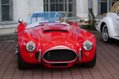 KYIV, UKRAINE, NOVEMBER 13, 2022: Red retro car stands at Expo Center. AC Cobra, sold in United States as Shelby Cobra and AC Shelby Cobra, is a sports car manufactured by British company AC Cars