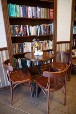 KOLOMYIA, UKRAINE, 20 AĞUSTOS: Masaları, sandalyeleri ve kitaplıkları olan kafenin içi