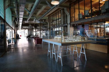 IVANO-FRANKIVSK, UKRAINE, AUGUST 20, 2022: People in coworking space PROMPRYLAD in former factory workshop. Coworking - arrangement in which workers of many companies share an office space