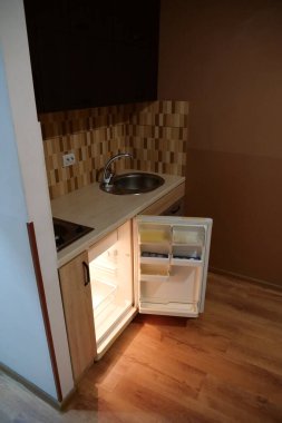 Built-in empty mini fridge with open door in kitchen