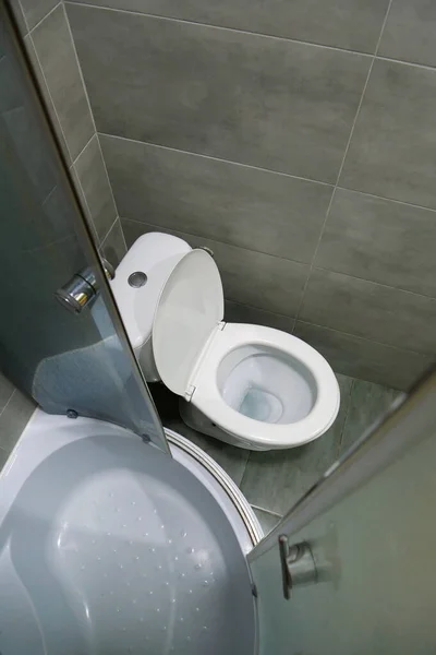 白いトイレボウル シャワーキャビン グレーの壁のタイルとトイレの部屋のインテリア — ストック写真