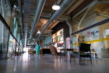 IVANO-FRANKIVSK, UKRAINE, AUGUST 20, 2022: People in coworking space PROMPRYLAD in former factory workshop. Coworking - arrangement in which workers of many companies share an office space