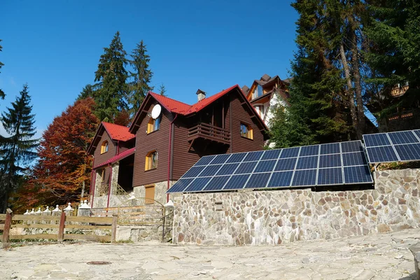 Panele Słoneczne Kamiennym Ogrodzeniu Pobliżu Drewnianego Domku Wsi Energia Odnawialna — Zdjęcie stockowe