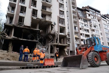KYIV, UKRAINE, APRIL 29, 2022: Workers clear rubble after bombing. Dwelling house damaged by russian missile on April 28, 2022. War in Ukraine. Terror and genocide of Ukrainian people