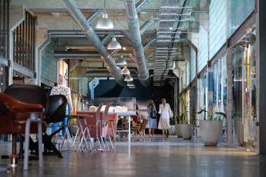IVANO-FRANKIVSK, UKRAINE, AUGUST 20, 2022: People in coworking space PROMPRYLAD in former factory workshop. Coworking - arrangement in which workers of many companies share an office space