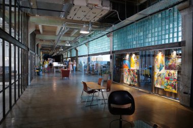 IVANO-FRANKIVSK, UKRAINE, AUGUST 20, 2022: People in coworking space PROMPRYLAD in former factory workshop. Coworking - arrangement in which workers of many companies share an office space