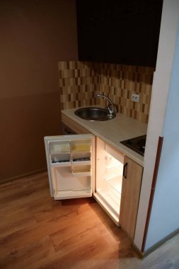 Built-in empty mini fridge with open door in the kitchen