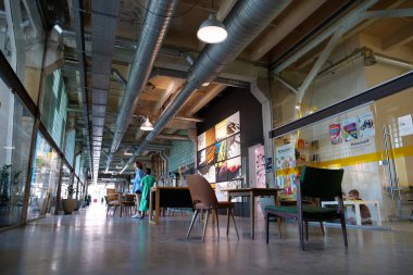 IVANO-FRANKIVSK, UKRAINE, AUGUST 20, 2022: People in coworking space PROMPRYLAD in former factory workshop. Coworking - arrangement in which workers of many companies share an office space