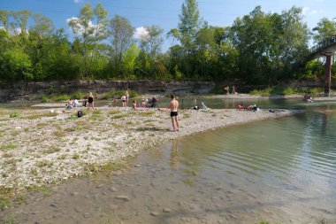 IVANO-FRANKIVSK, UKRAINE, AUGUST 19, 2022: People rests by river in Ivano-Frankivsk city in western Ukraine