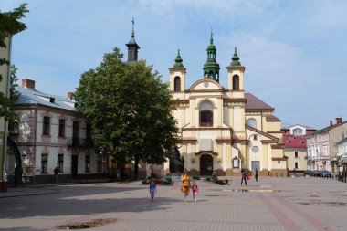 IVANO-FRANKIVSK, UKRAINE, AUGUST 22, 2022: People near Church of the Blessed Virgin Mary, an now art museum on Sheptitskogo Square in Ivano-Frankivsk city, western Ukraine