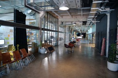 IVANO-FRANKIVSK, UKRAINE, AUGUST 20, 2022: People in coworking space PROMPRYLAD in former factory workshop. Coworking - arrangement in which workers of many companies share an office space