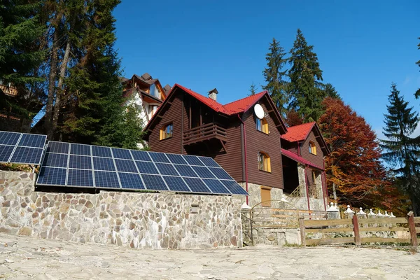 Panele Słoneczne Kamiennym Ogrodzeniu Pobliżu Drewnianego Domku Wsi Energia Odnawialna — Zdjęcie stockowe
