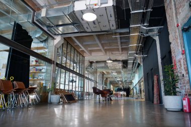 IVANO-FRANKIVSK, UKRAINE, AUGUST 20, 2022: People in coworking space PROMPRYLAD in former factory workshop. Coworking - arrangement in which workers of many companies share an office space