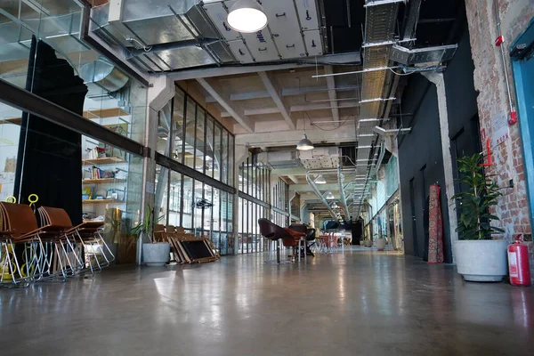 IVANO-FRANKIVSK, UKRAINE, AĞUSTOS 20, 2022: Eski fabrika atölyesinde birlikte çalışan insanlar. Ortak çalışma - birçok şirketin işçilerinin ofis alanını paylaştığı bir düzenleme