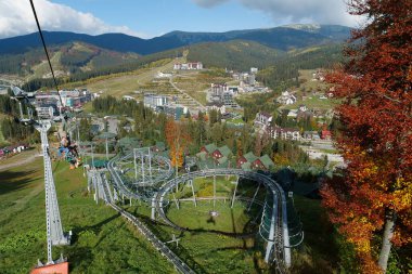 BUKOVEL, UKRAINE, OKTOBER 13 Ekim 2022: Bukovel 'de kayak asansöründeki insanlar - Karpat Dağları' ndaki güzel köy ve en büyük kayak merkezi, Ivano-Frankivsk Oblastı, batı Ukrayna