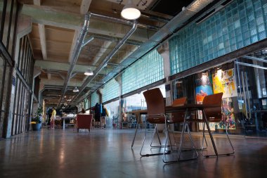 IVANO-FRANKIVSK, UKRAINE, AUGUST 20, 2022: People in coworking space PROMPRYLAD in former factory workshop. Coworking - arrangement in which workers of many companies share an office space