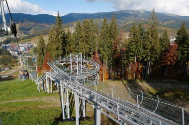 BUKOVEL, UKRAINE, OKTOBER 13 Ekim 2022: Bukovel 'de kayak asansöründeki insanlar - Karpat Dağları' ndaki güzel köy ve en büyük kayak merkezi, Ivano-Frankivsk Oblastı, batı Ukrayna