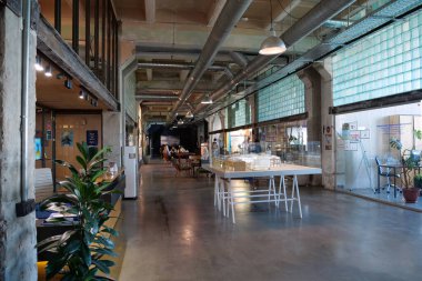 IVANO-FRANKIVSK, UKRAINE, AUGUST 20, 2022: People in coworking space PROMPRYLAD in former factory workshop. Coworking - arrangement in which workers of many companies share an office space