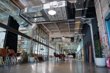 IVANO-FRANKIVSK, UKRAINE, AUGUST 20, 2022: People in coworking space PROMPRYLAD in former factory workshop. Coworking - arrangement in which workers of many companies share an office space
