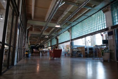 IVANO-FRANKIVSK, UKRAINE, AUGUST 20, 2022: People in coworking space PROMPRYLAD in former factory workshop. Coworking - arrangement in which workers of many companies share an office space