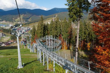 BUKOVEL, UKRAINE, OKTOBER 13 Ekim 2022: Bukovel 'de kayak asansöründeki insanlar - Karpat Dağları' ndaki güzel köy ve en büyük kayak merkezi, Ivano-Frankivsk Oblastı, batı Ukrayna