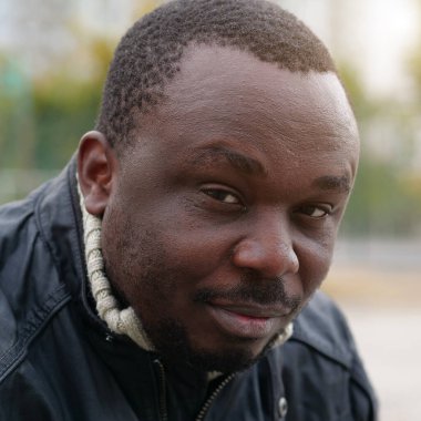 Nijeryalı Afrikalı Amerikalı adam kameraya bakıyor.