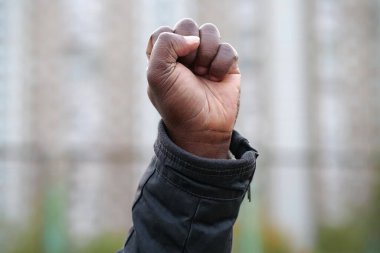 Protesto etmek için zenci yumruğunu kaldırdı. Afro-Amerikan, sosyal adalet ve ırkçı adaletsizliği barışçıl bir şekilde protesto eden