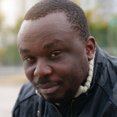 Nijeryalı Afrikalı Amerikalı adam kameraya bakıyor.