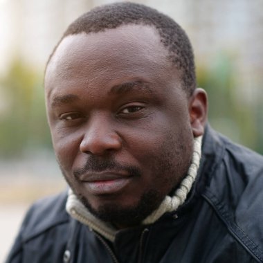 Nijeryalı Afrikalı Amerikalı adam kameraya bakıyor.