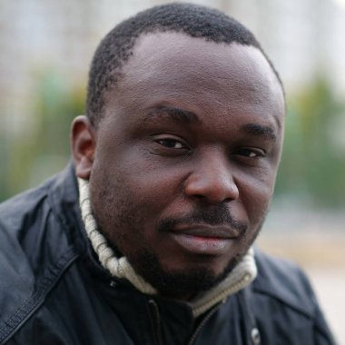 Nijeryalı Afrikalı Amerikalı adam kameraya bakıyor.