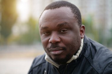 Nijeryalı Afrikalı Amerikalı adam kameraya bakıyor.