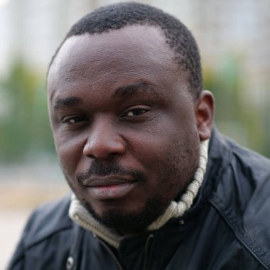Nijeryalı Afrikalı Amerikalı adam kameraya bakıyor.