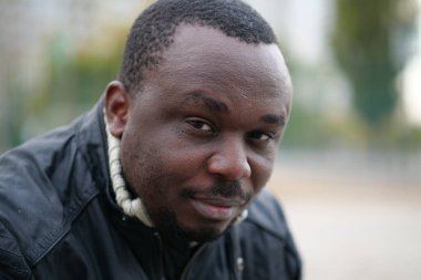Nijeryalı Afrikalı Amerikalı adam kameraya bakıyor.
