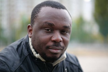 Nijeryalı Afrikalı Amerikalı adam kameraya bakıyor.