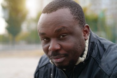 Nijeryalı Afrikalı Amerikalı adam kameraya bakıyor.