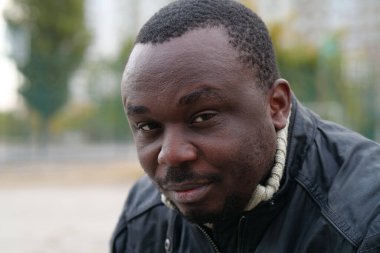 Nijeryalı Afrikalı Amerikalı adam kameraya bakıyor.