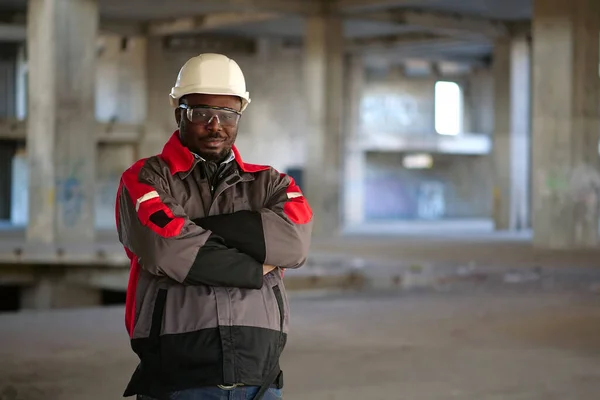 Afrikansk Amerikan Arbetare Vit Hatt Och Skyddsglasögon Står Byggområdet Tittar — Stockfoto