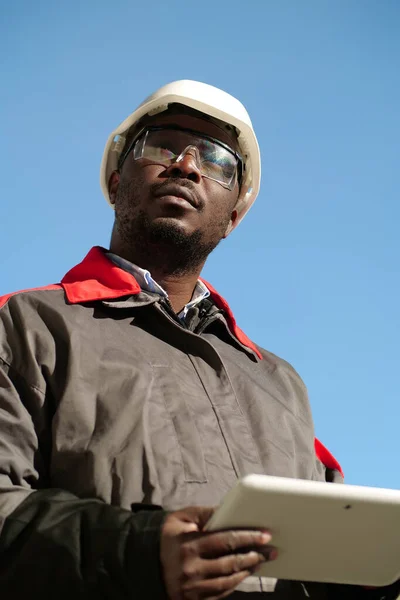 모자를 보호용 고글을 타블렛 컴퓨터가 아프리카 미국인 근로자가 현장에 — 스톡 사진