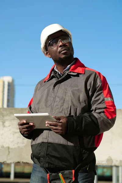 모자를 보호용 고글을 타블렛 컴퓨터가 아프리카 미국인 근로자가 현장에 — 스톡 사진