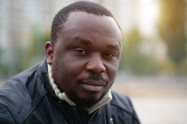 Nijeryalı Afrikalı Amerikalı adam kameraya bakıyor.