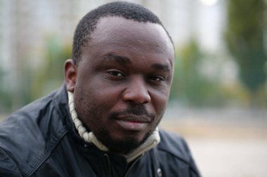 Nijeryalı Afrikalı Amerikalı adam kameraya bakıyor.